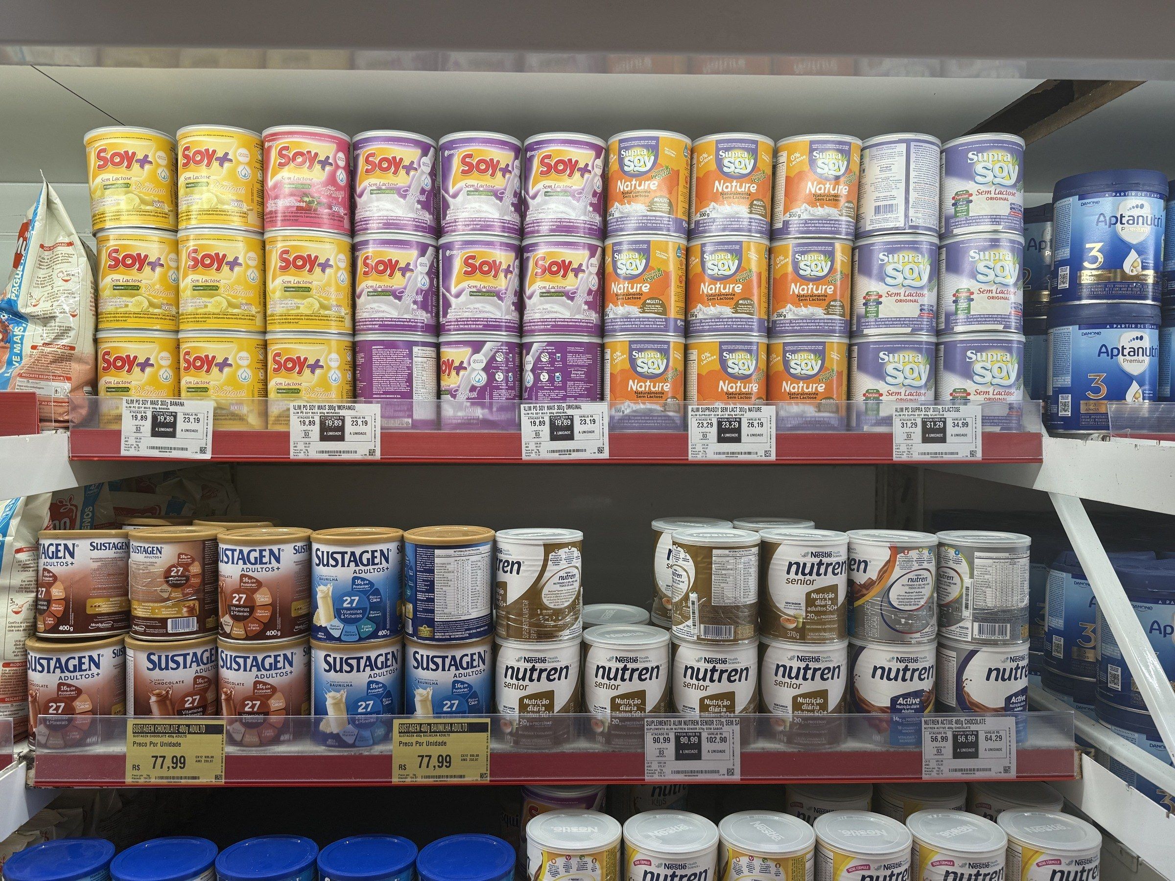 SupraSoy e Soy+ expostos na seção de bebidas em pó, com preço conferido. Grande Fortaleza.